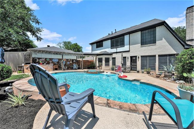 Backyard paradise features a sparkling pool/spa, covered patio and outdoor kitchen/bar area. | Image 21