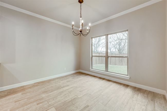 Unfurnished room featuring a chandelier, light wood-style flooring, baseboards, and ornamental molding | Image 5