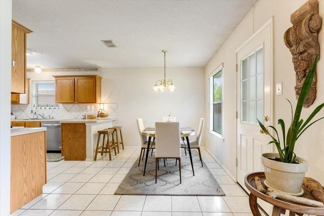 This photo showcases a bright, open kitchen and dining area with white tile flooring. | Image 10