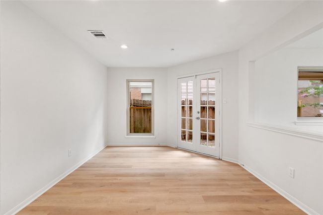 Dining area framed by French doors and recessed lighting, with a pass-through to the kitchen for flow. | Image 7