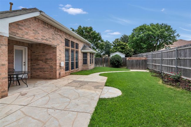 Fenced backyard with a patio | Image 5