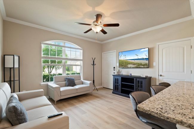 Living room featuring ceiling fan, light wood finished floors, ornamental molding, and baseboards | Image 29