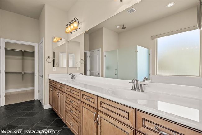 Full bath featuring a sink, double vanity, tile patterned flooring, and a stall shower | Image 43