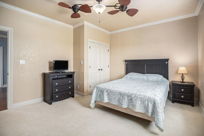Nestled at the top of the stairs, this substantial secondary bedroom offers a comfortable retreat. Its generous size allows for flexible furnishing, while the addition of crown molding provides a touch of classic charm. | Image 30