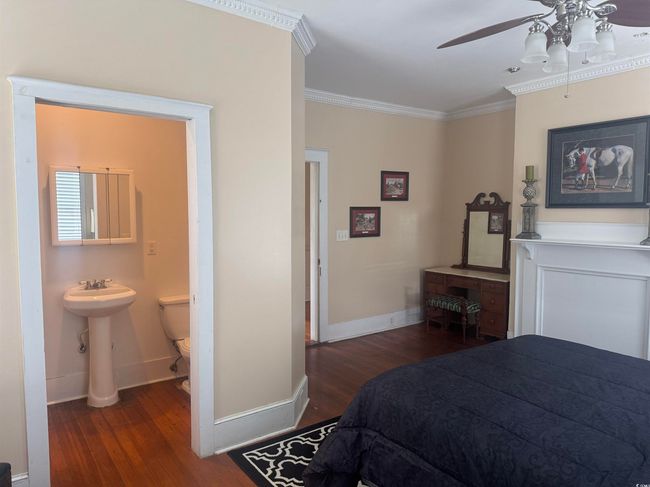Bedroom with wood finished floors, ornamental molding, ensuite bath, and a ceiling fan | Image 18
