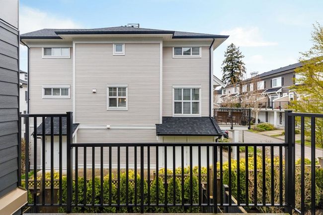 Back of house with roof with shingles, a residential view, and a balcony | Image 11