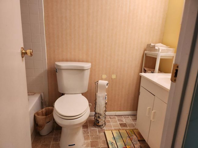Bathroom featuring a tub to relax in, toilet, and vanity | Image 15