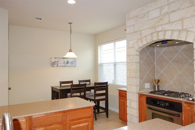 Built in oven and cooktop with a brick surround. | Image 7