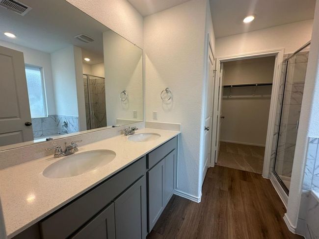 Full bathroom with a stall shower, wood finished floors, a walk in closet, double vanity, and recessed lighting | Image 22