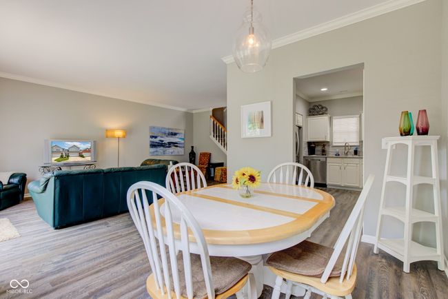 dining room featuring light wood-style floors, stairs, and ornamental molding | Image 10