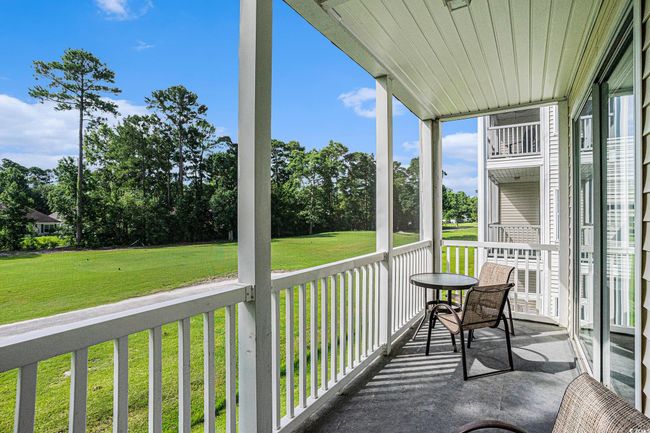 Covered porch with view of wooded area | Image 21