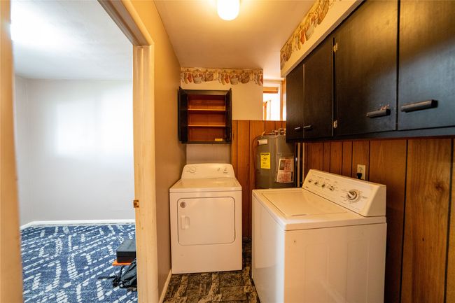 Laundry area with cabinet space, water heater, washing machine and dryer, and baseboards | Image 22