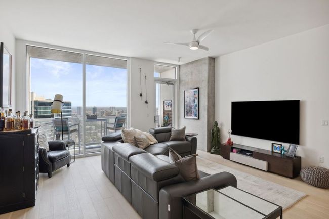 Living room with a wall of windows, light wood-style flooring, and a ceiling fan | Image 11