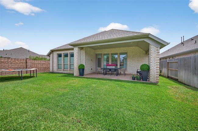 Generous backyard with covered patio, ample green space, and full fencing on all sides. Ideal setup for pets, play, or adding a garden or outdoor kitchen. | Image 31