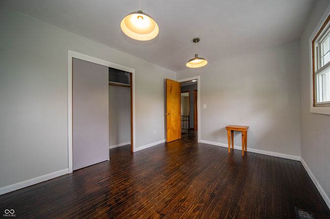 unfurnished bedroom featuring baseboards, wood-type flooring, and a closet | Image 31
