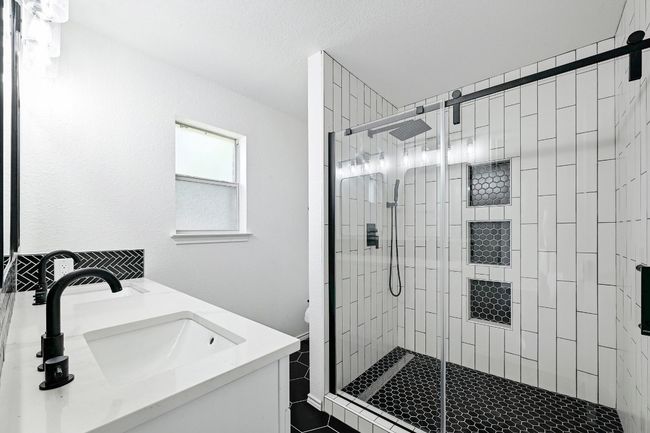 Bathroom featuring a stall shower and double vanity | Image 20