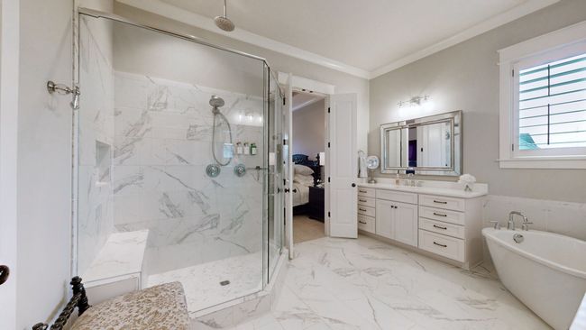 This master bathroom is a true retreat—featuring a spacious walk-in shower w/bench & rain showerhead, a freestanding soaking tub, dual vanities, and elegant marble-style tile throughout. Pure luxury from start to finish. | Image 31