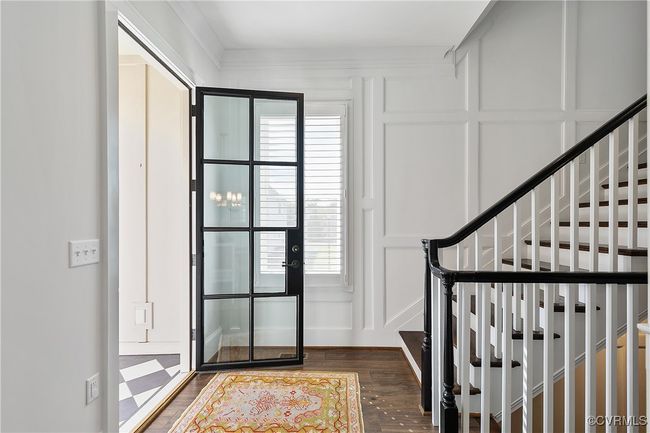 Entryway with stairs, dark wood-style flooring, and a decorative wall | Image 4