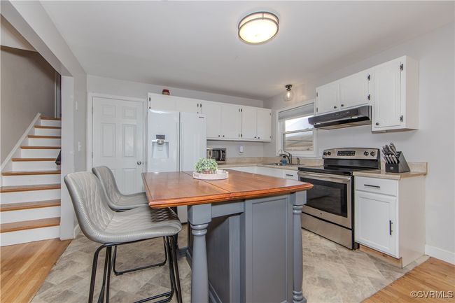 Kitchen with white cabinets, stainless steel appliances, and light hardwood / wood-style flooring | Image 16