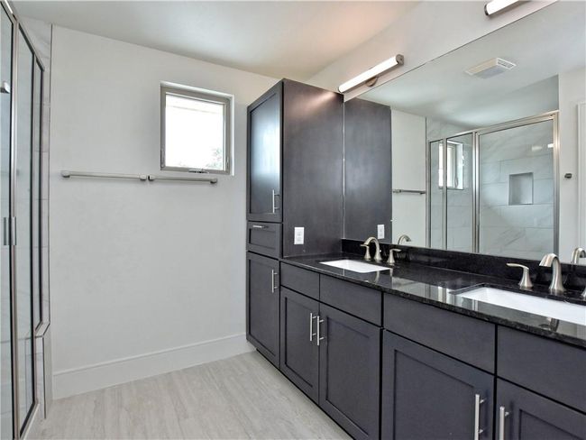 Bathroom featuring a shower stall and double vanity | Image 12