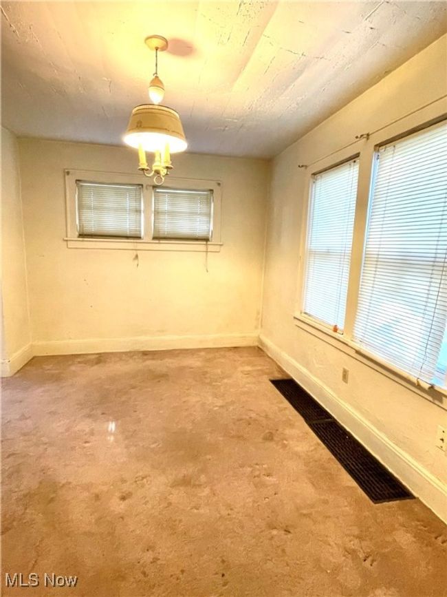 Spare room with baseboards and a chandelier | Image 6