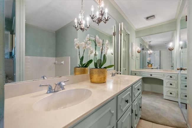 Full bathroom with a chandelier, double vanity, crown molding, and tile patterned floors | Image 23