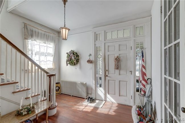 Entryway featuring radiator, stairs, and wood finished floors | Image 7