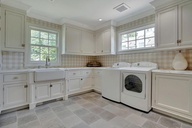 Laundry room w. custom cabinetry, marble counter tops and electric built-in ironing board | Image 15