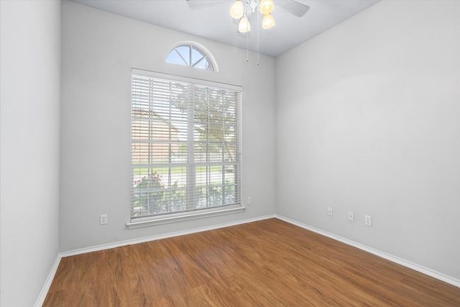 This bedroom has a large window looking out to the front yard | Image 18