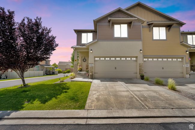 View of front of home with stone siding, a front lawn, an attached garage, and driveway | Image 27