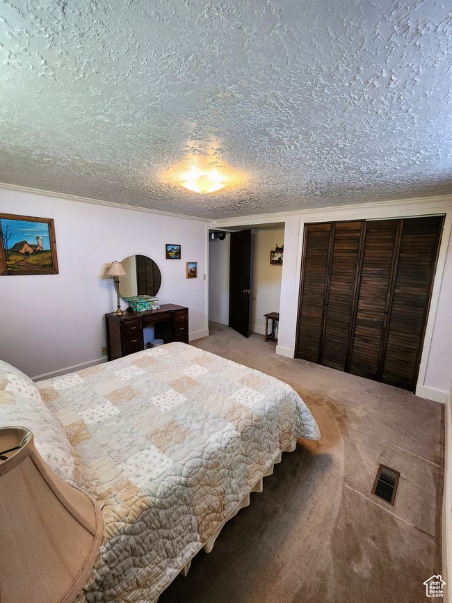 Bedroom featuring two closets, a textured ceiling, baseboards, and visible vents | Image 41