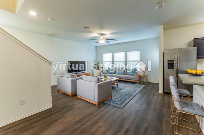Virtually Staged- Living room with dark wood-type flooring, baseboards, visible vents, and ceiling fan | Image 5