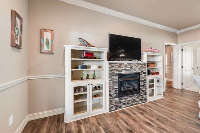 The gas fireplace is perfect for cozy nights with friends and family and is flanked with built ins to keep movies, games and books stashed away. | Image 10