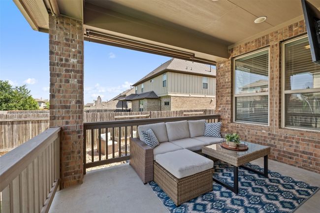 Relax in style with a covered outdoor living area enhanced by retractable sunshades for flexible comfort. | Image 31