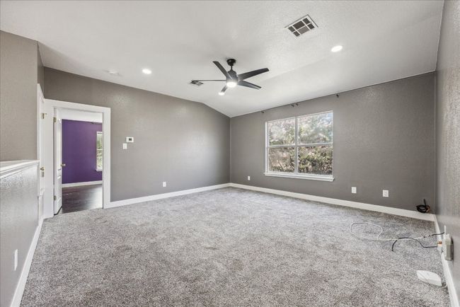 Unfurnished room with vaulted ceiling, visible vents, carpet floors, baseboards, and ceiling fan | Image 21