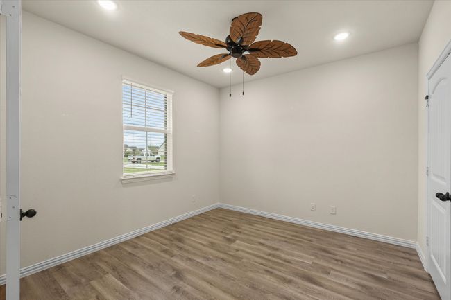 Empty room with a ceiling fan, wood finished floors, and recessed lighting | Image 7