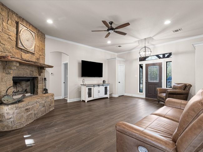 Featuring a wood burning fireplace, ample space and ceiling fan | Image 4