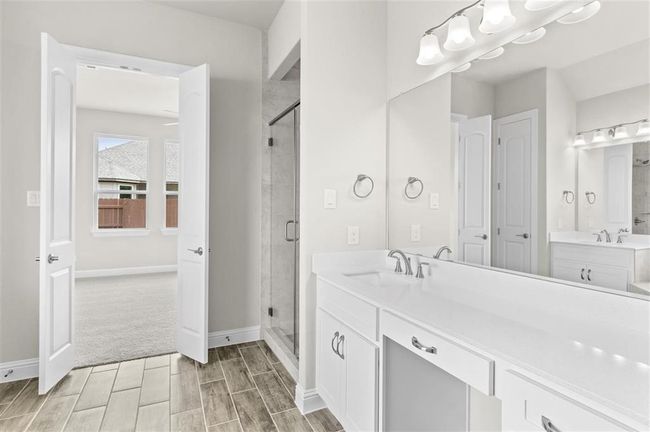 Bathroom with a stall shower, vanity, wood tiled floors, and baseboards | Image 15