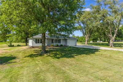 Ranch-style house with a garage and a front yard | Image 2