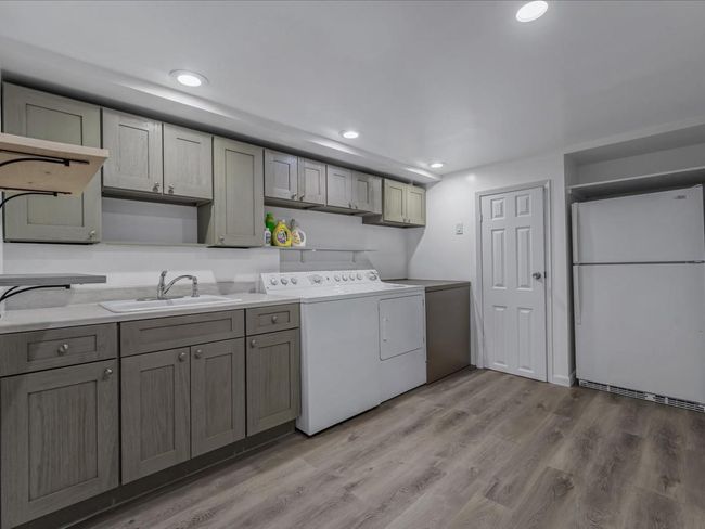 Laundry room featuring independent washer and dryer, light wood-type flooring, cabinet space, and recessed lighting | Image 29