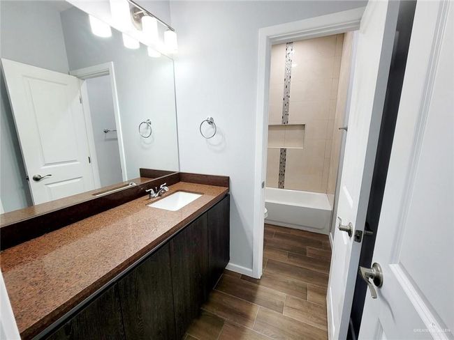 Full bathroom with toilet, vanity, baseboards, and wood finish floors | Image 14