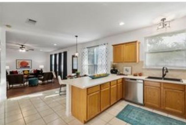 Kitchen featuring a sink, light countertops, light tile patterned flooring, dishwasher, and a peninsula | Image 8
