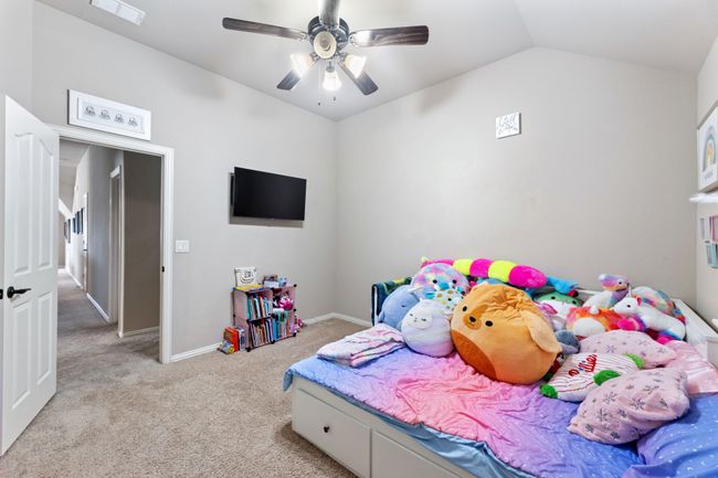 Bedroom with lofted ceiling, light colored carpet, and ceiling fan | Image 23