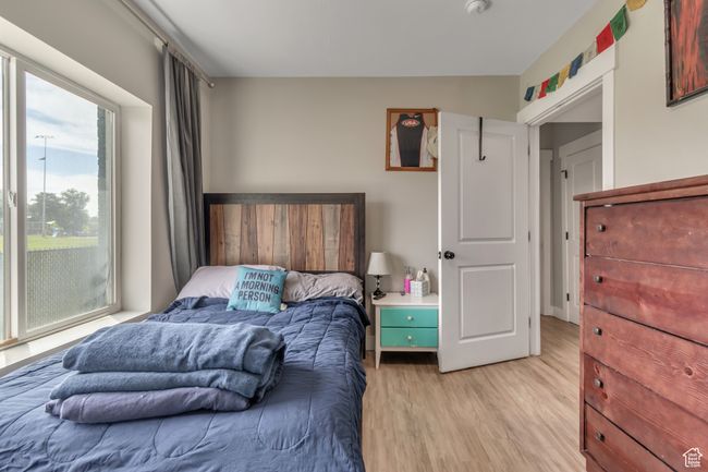 Bedroom with light wood-type flooring | Image 11