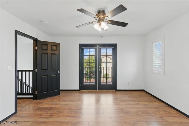 Primary bedroom with a ceiling fan, french doors leading out to the balcony | Image 13