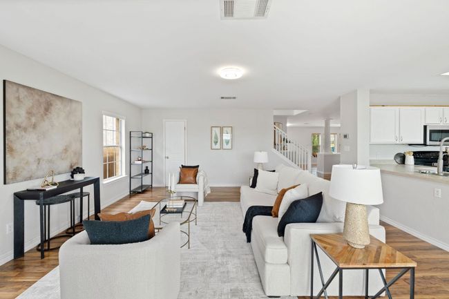 Living room featuring light wood finished floors, plenty of natural light, stairs, and baseboards | Image 11