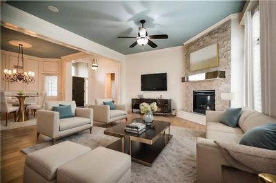 Living room with a fireplace, ceiling fan with notable chandelier, and hardwood / wood-style floors | Image 3