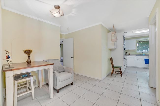 Living area with crown molding, light tile patterned floors, and baseboards | Image 23
