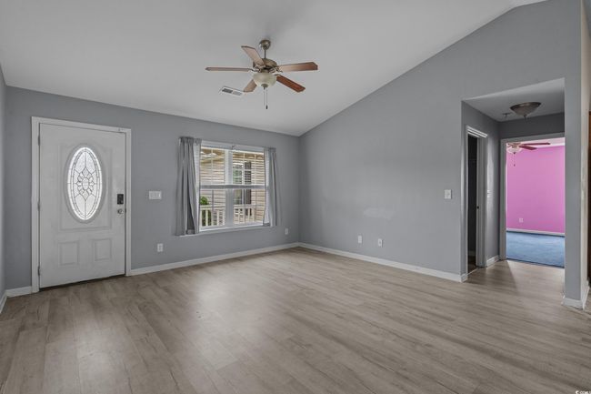 Foyer entrance featuring a ceiling fan, vaulted ceiling, healthy amount of natural light, wood finished floors, and baseboards | Image 15