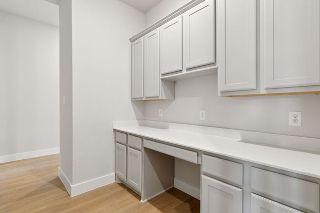 Kitchen with built in desk, light wood-style flooring, and light countertops | Image 28